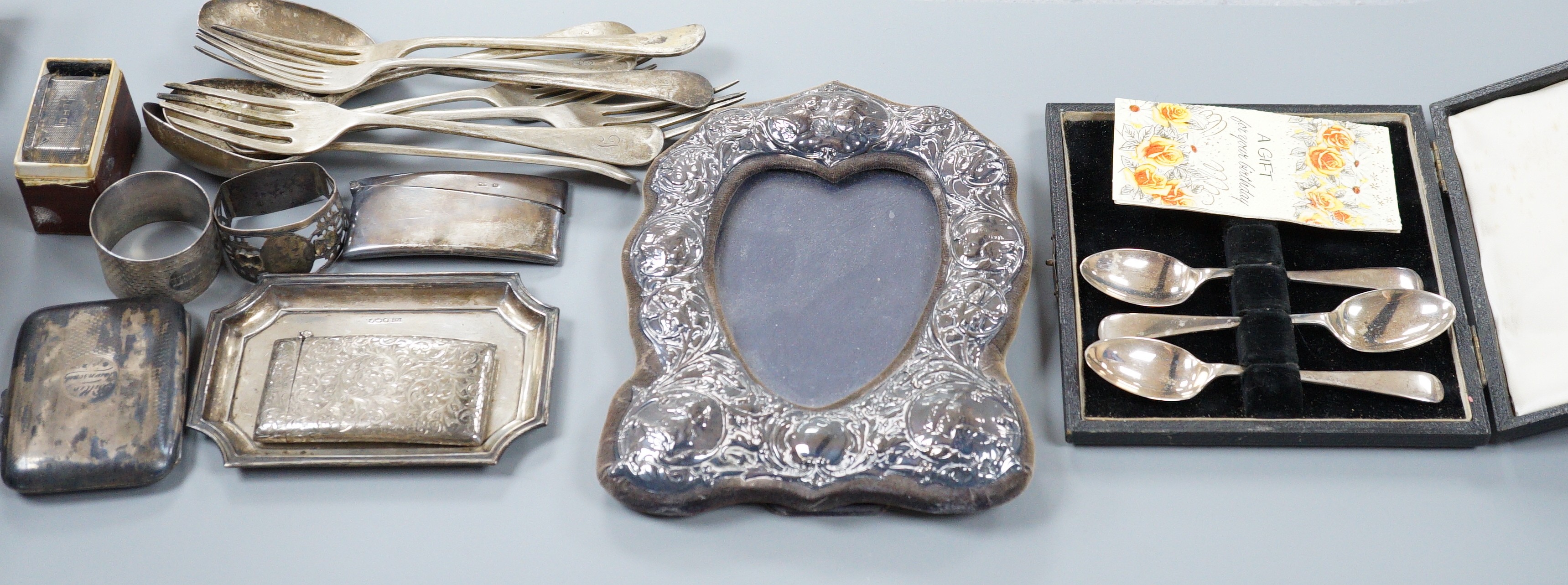 A mixed collection of silver to include cutlery, napkin rings, photograph frame, card cases, small dish, etc.